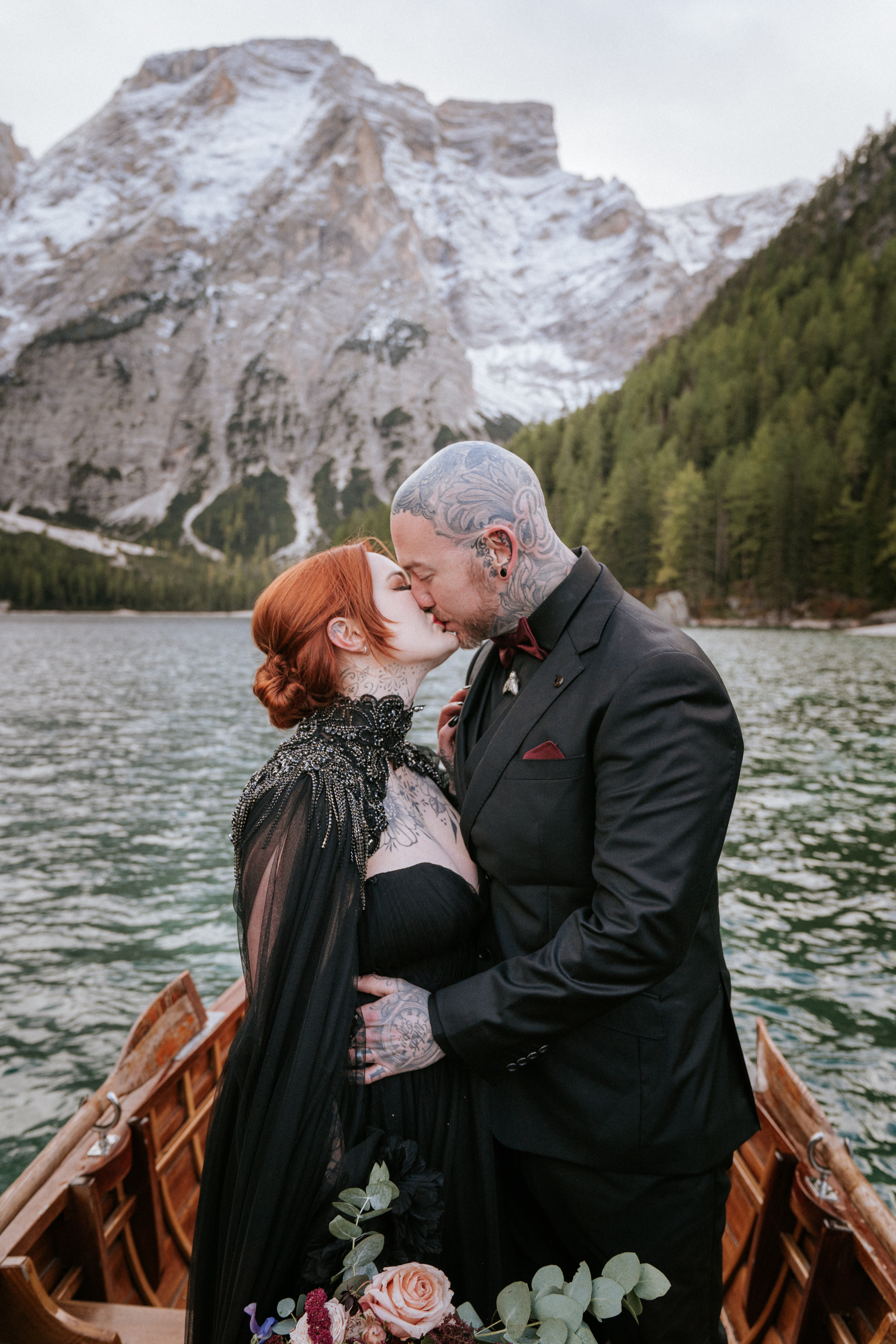 Couple sharing a tender moment at the boathouse dock at Lago di Braies – intimate Lago di Braies wedding photographer South Tyrol