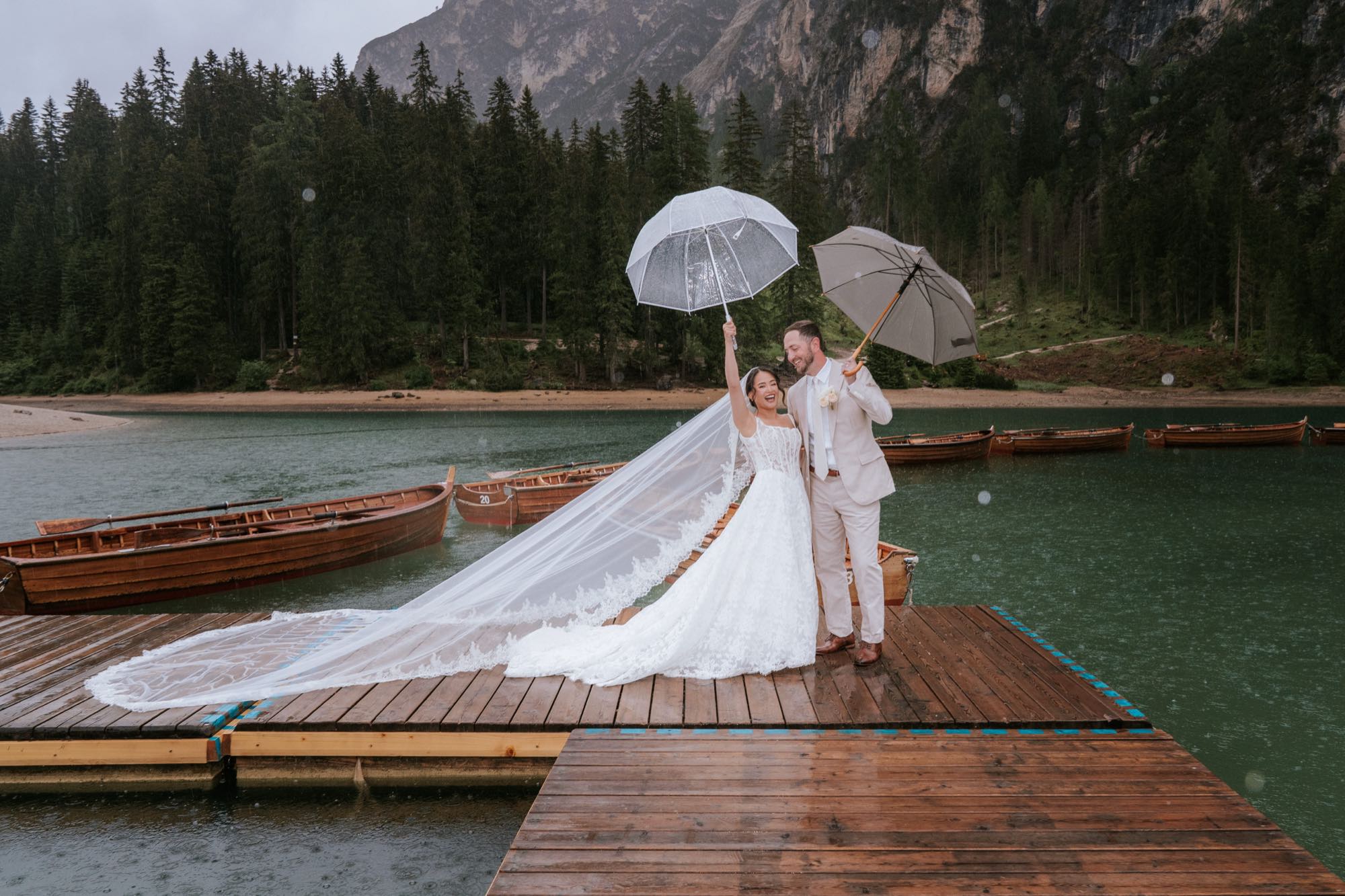 Couple at Lago di Braies on a rainy morning with mist drifting over the Dolomites – Lago di Braies wedding photographer in every weather