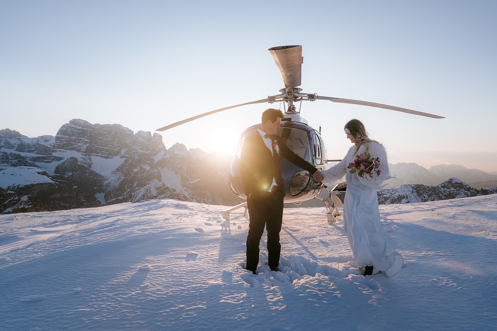 Winterliche Hubschrauber-Hochzeit im Schnee bei Sonnenuntergang