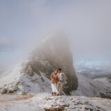 Couple arriving by helicopter at Tre Cime di Lavaredo for Dolomites winter elopement.